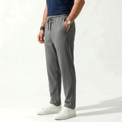 Man wearing MannerCo army green jacquard ribbed drawstring trousers, side view on plain background