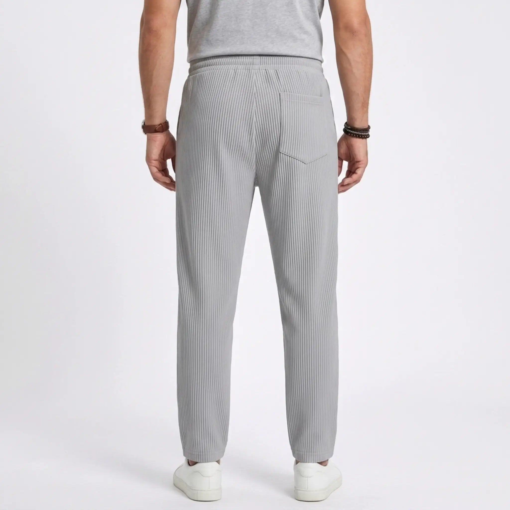 Man wearing MannerCo black jacquard ribbed drawstring trousers, back view on plain background