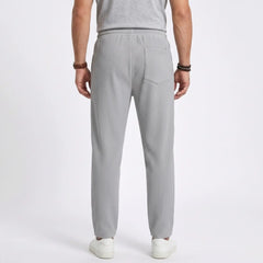 Man wearing MannerCo black jacquard ribbed drawstring trousers, back view on plain background