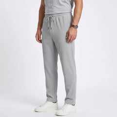 Man wearing MannerCo black jacquard ribbed straight leg drawstring trousers in outdoor lifestyle setting