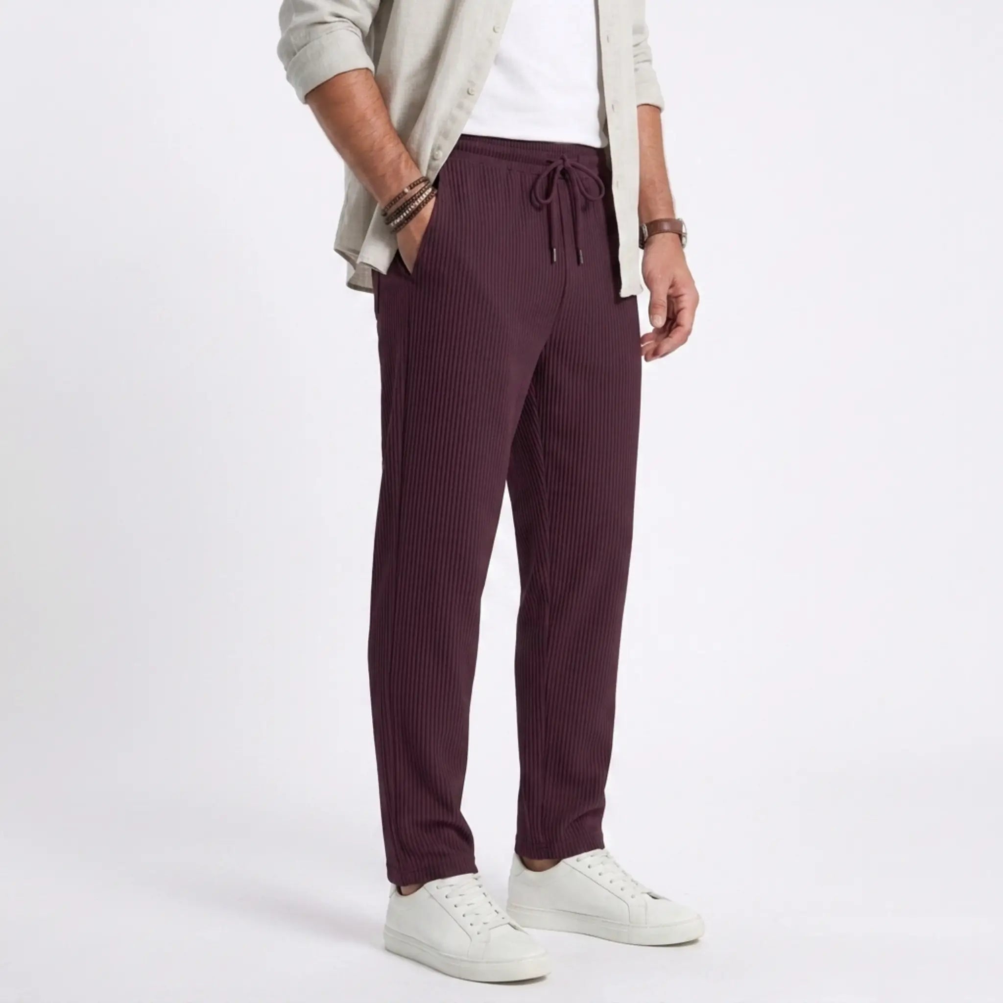 Man wearing MannerCo light gray jacquard ribbed straight leg drawstring trousers, front view on plain background