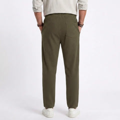 Man wearing MannerCo light gray jacquard ribbed drawstring trousers outdoors in urban setting