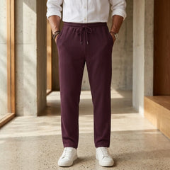 Man wearing MannerCo light gray jacquard ribbed drawstring trousers in outdoor lifestyle setting