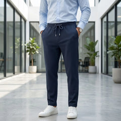Man wearing MannerCo navy jacquard ribbed straight leg drawstring trousers, front view on plain background