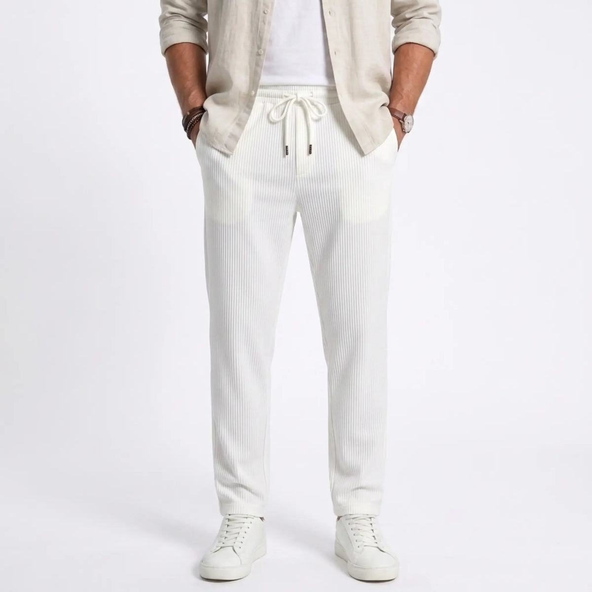 Man wearing MannerCo white jacquard ribbed straight leg drawstring trousers, front view on plain background