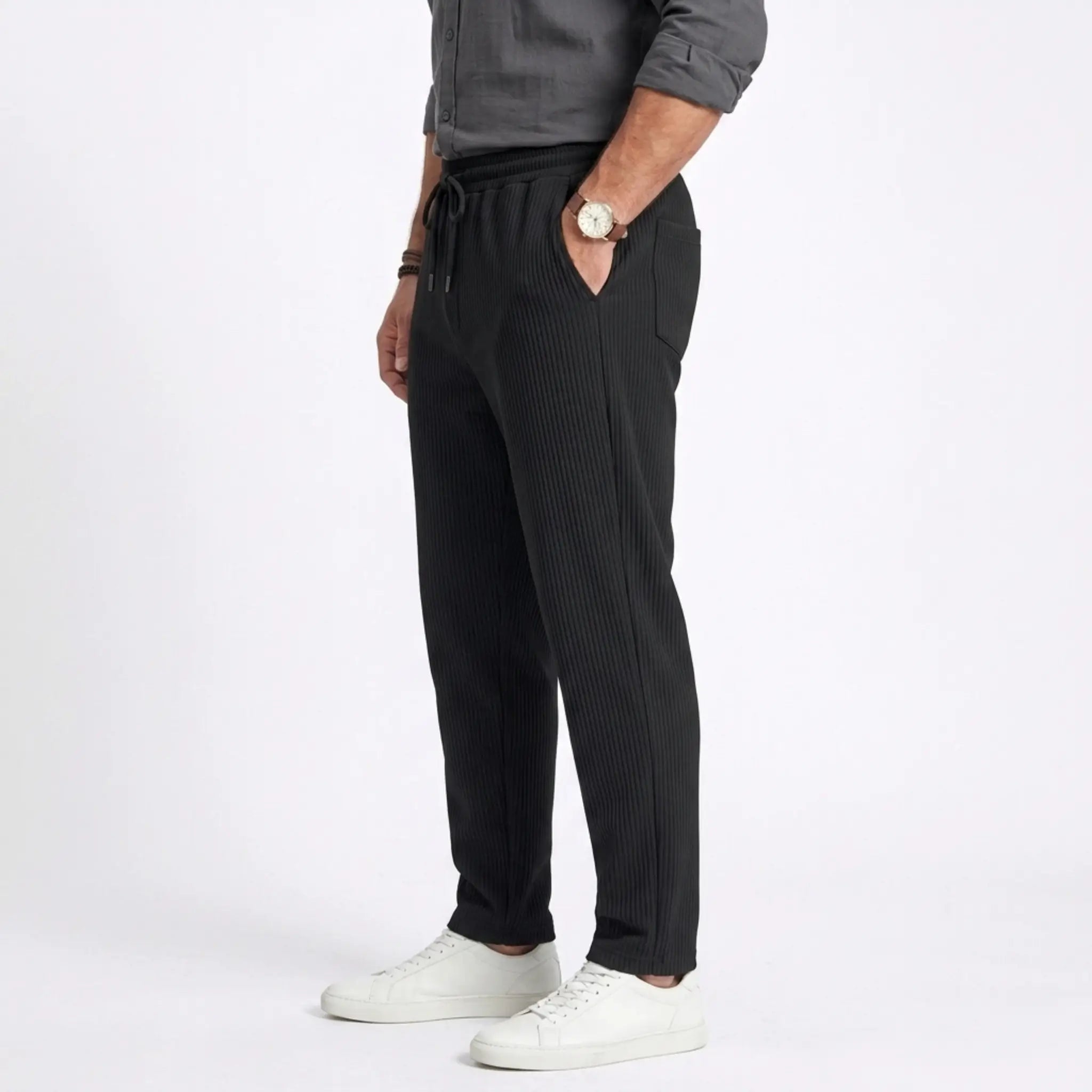 Man wearing MannerCo white jacquard ribbed straight leg drawstring trousers outdoors in urban setting