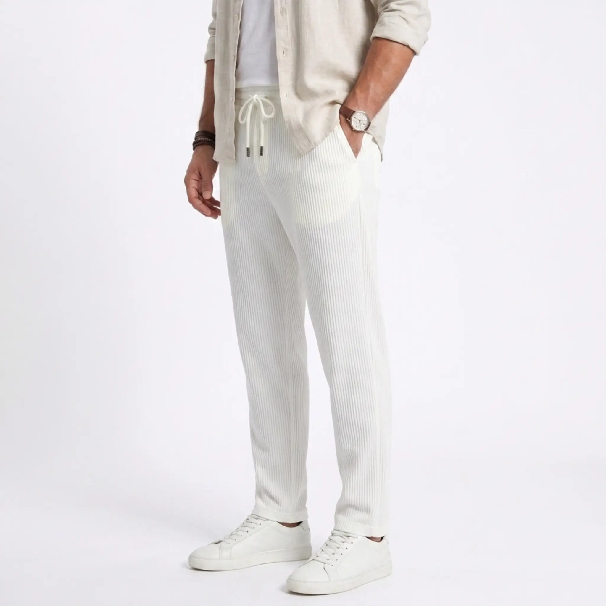 Man wearing MannerCo white jacquard ribbed straight leg drawstring trousers, side view on plain background