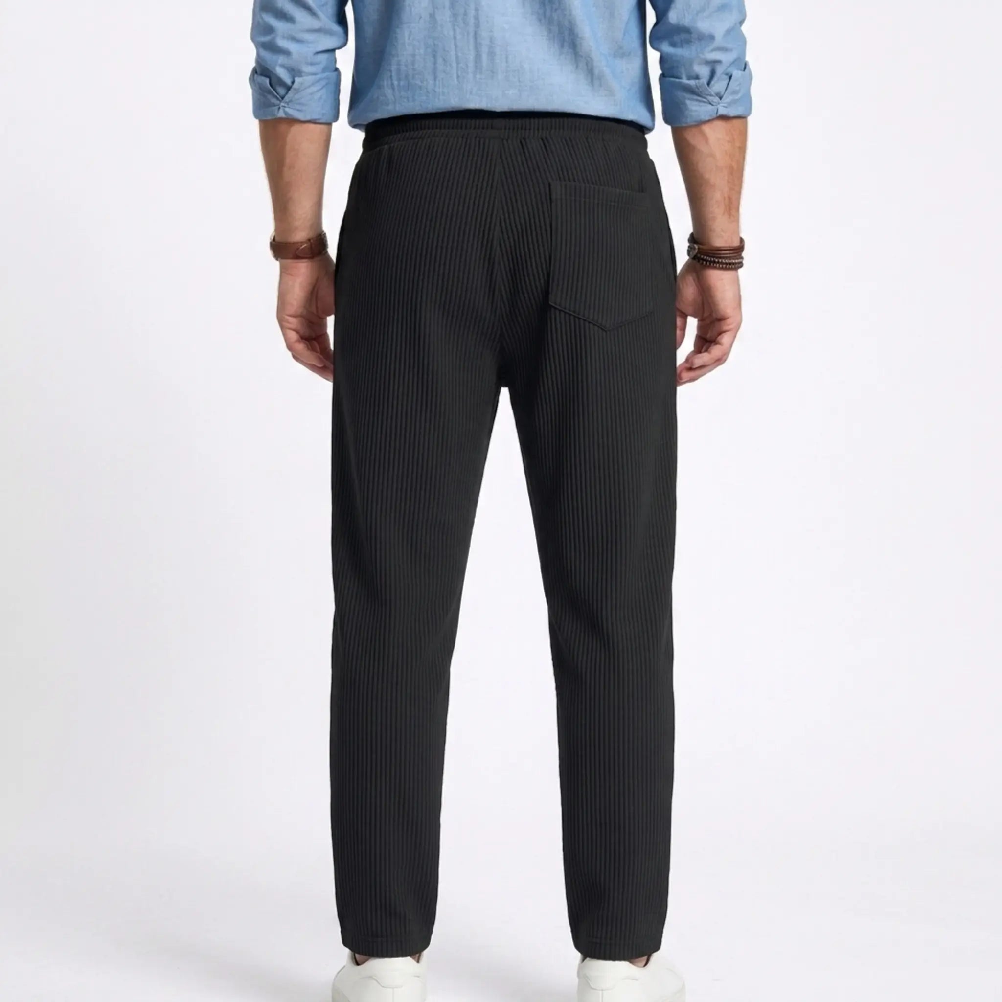 Man wearing MannerCo white jacquard ribbed drawstring trousers, three quarter view on plain background