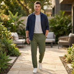 Man wearing MannerCo wine red jacquard ribbed straight leg drawstring trousers, side view on plain background