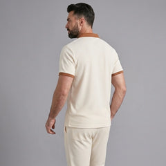 Three quarter view of man in khaki color block waffle polo and straight leg pants