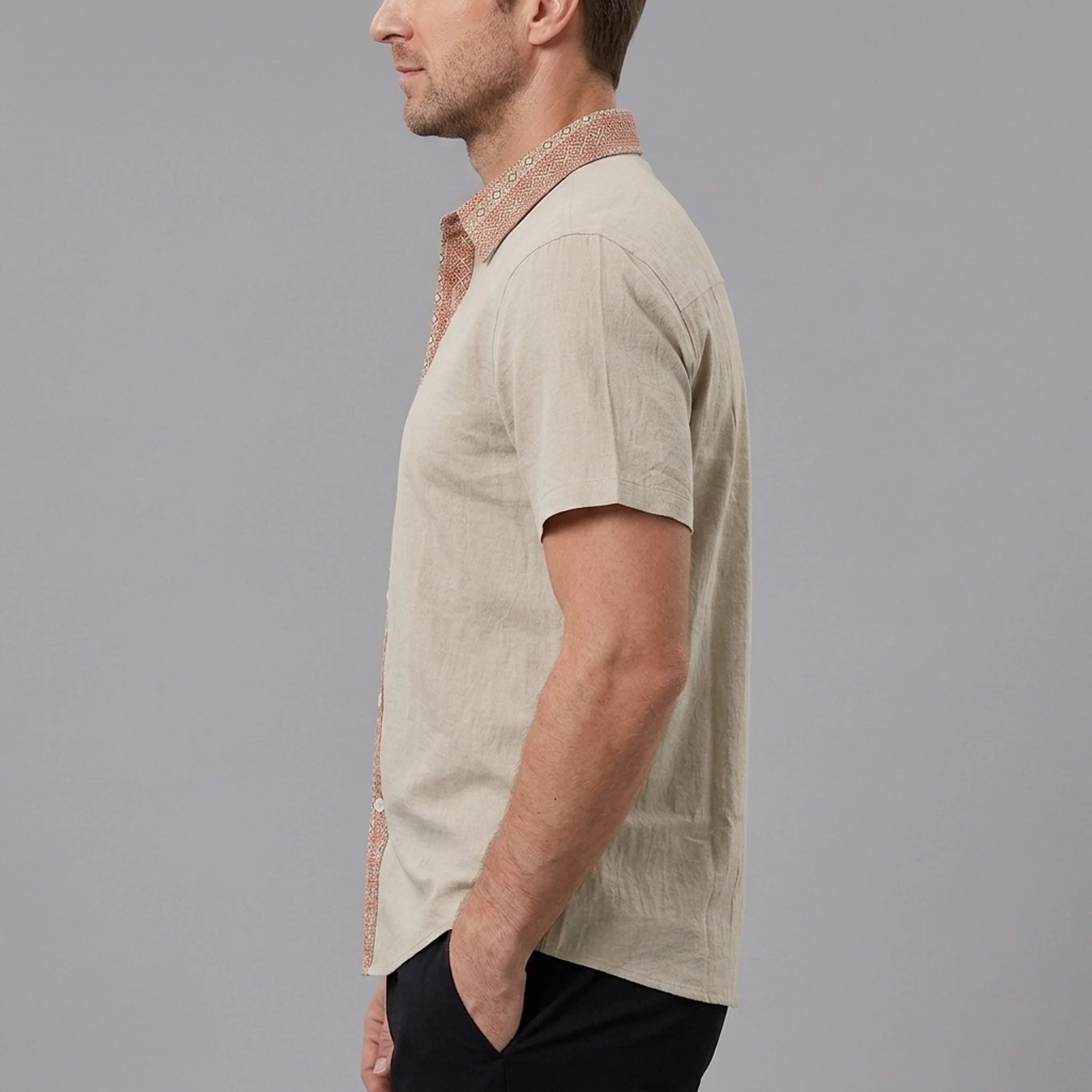 MannerCo men's khaki linen blend short sleeve shirt with contrast red print collar, side view on model