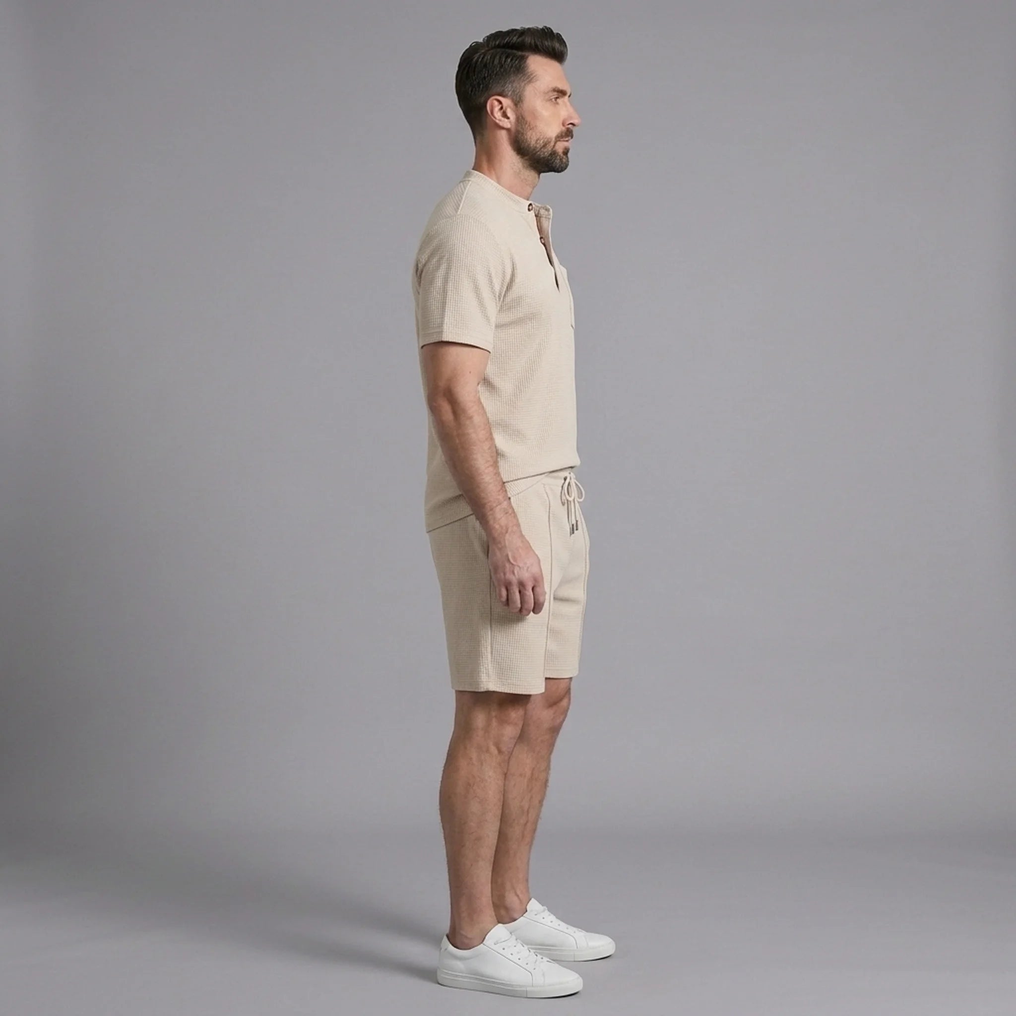Man wearing a khaki waffle stand collar button up shirt and drawstring shorts front view