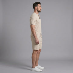 Man wearing a khaki waffle stand collar button up shirt and drawstring shorts front view