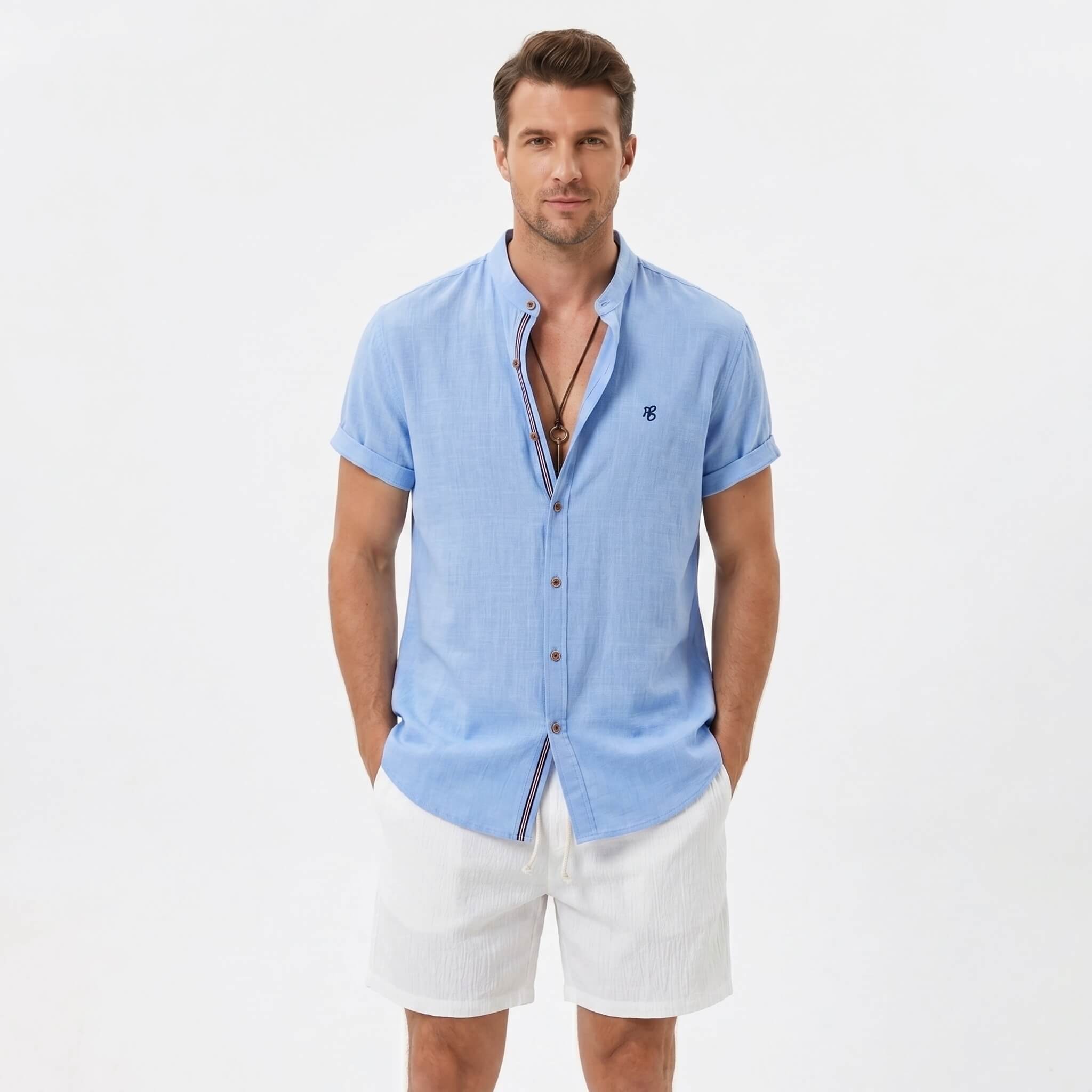 Man wearing a light blue linen look stand collar shirt and crinkle textured drawstring shorts front view