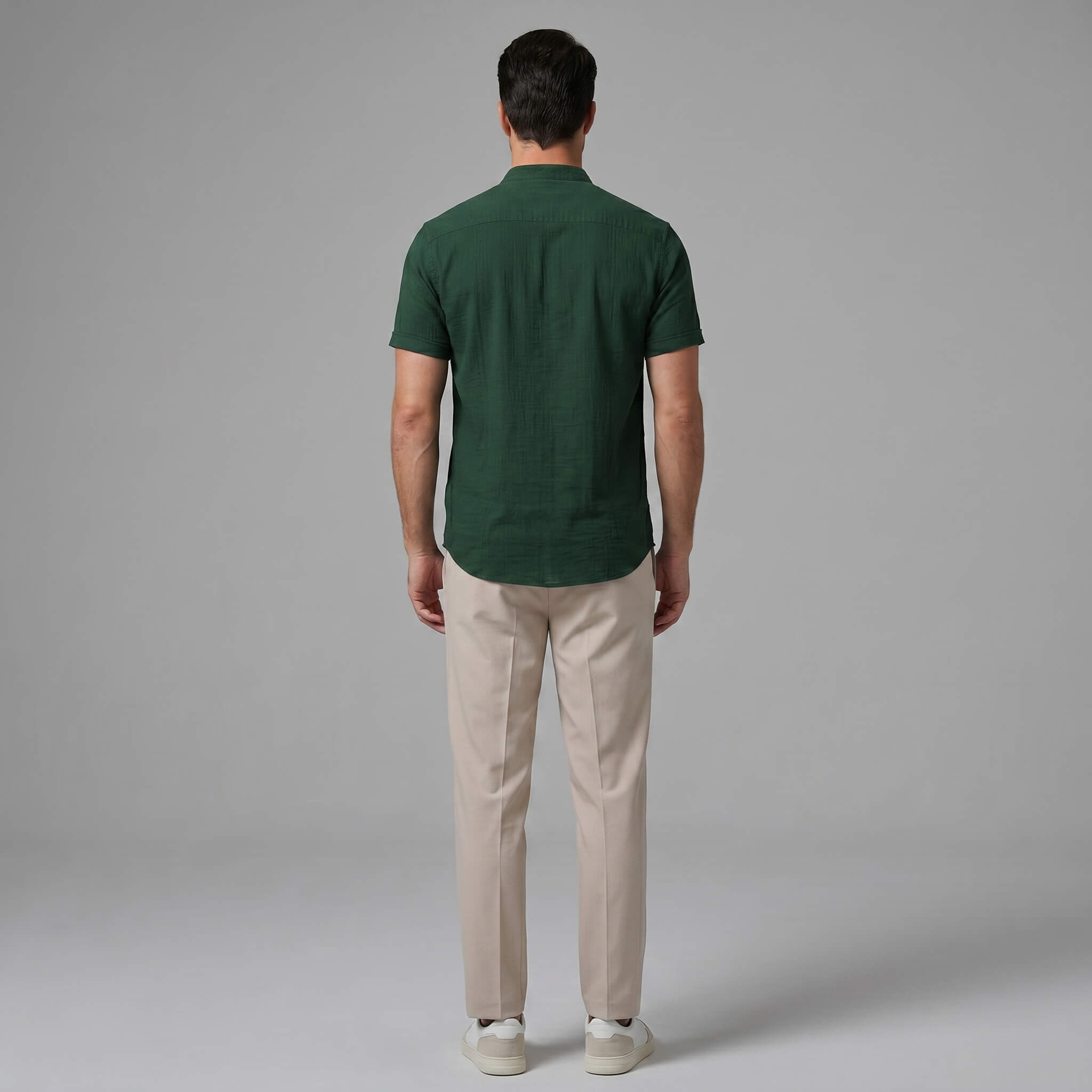 Back view of man wearing light blue linen look stand collar shirt and slim fit tapered trousers