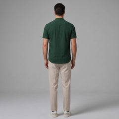 Back view of man wearing light blue linen look stand collar shirt and slim fit tapered trousers
