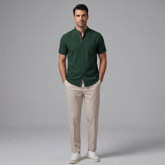Man wearing a light blue linen look stand collar shirt and slim fit tapered trousers front view on plain background