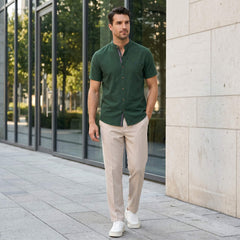 Man in light blue linen look stand collar shirt and slim tapered trousers in sunny outdoor summer scene