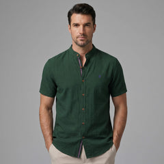 Three quarter view of man in light blue linen look stand collar shirt and slim tapered trousers