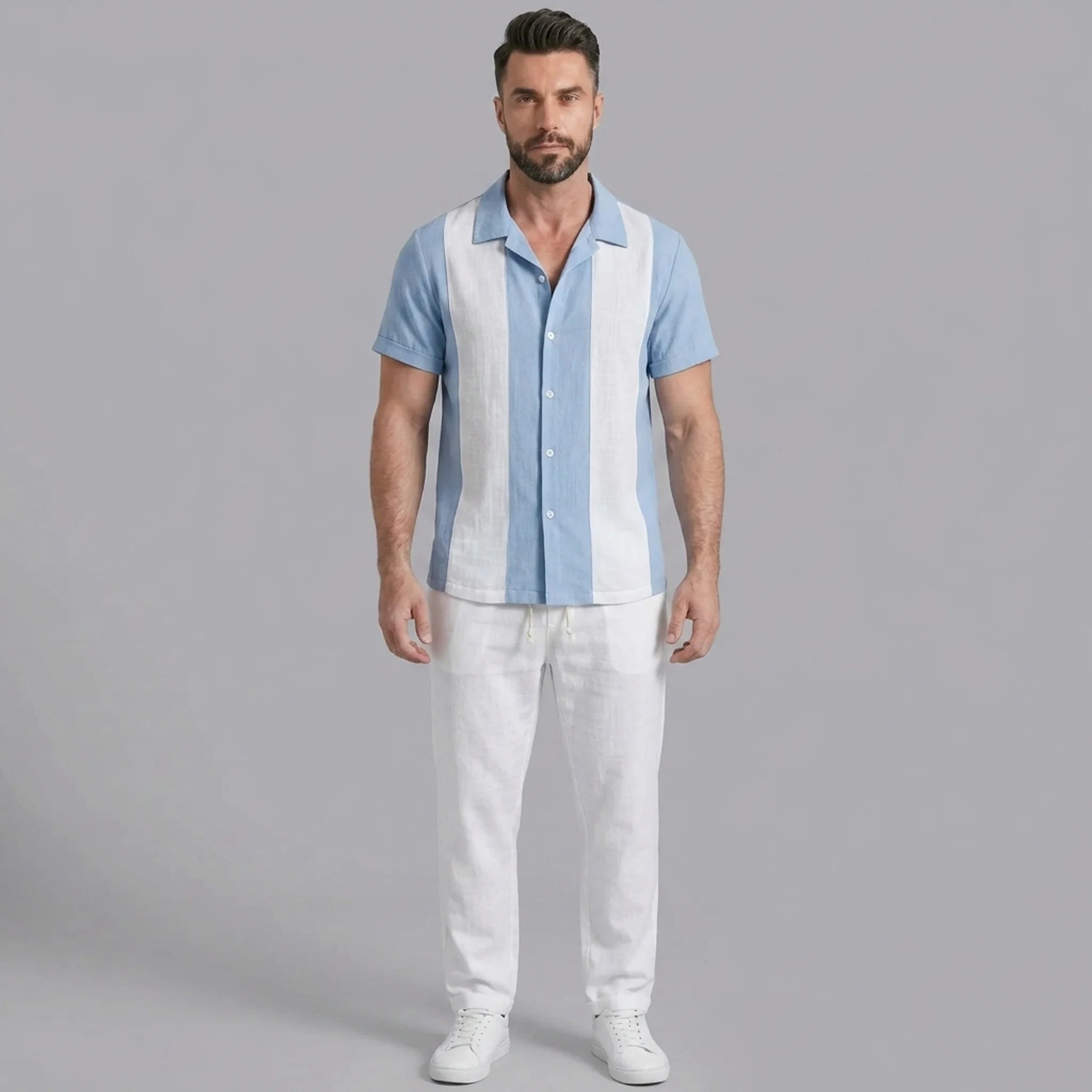 Man wearing a light blue patchwork cotton bowling shirt and straight leg linen pants front view on plain background