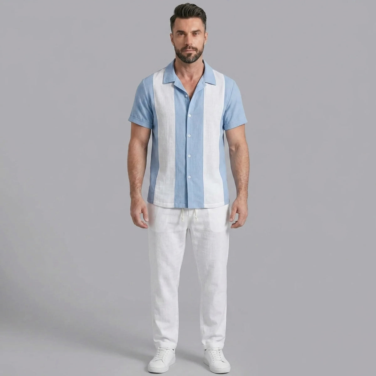 Man wearing a light blue patchwork cotton bowling shirt and straight leg linen pants front view on plain background