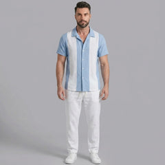 Man wearing a light blue patchwork cotton bowling shirt and straight leg linen pants front view on plain background