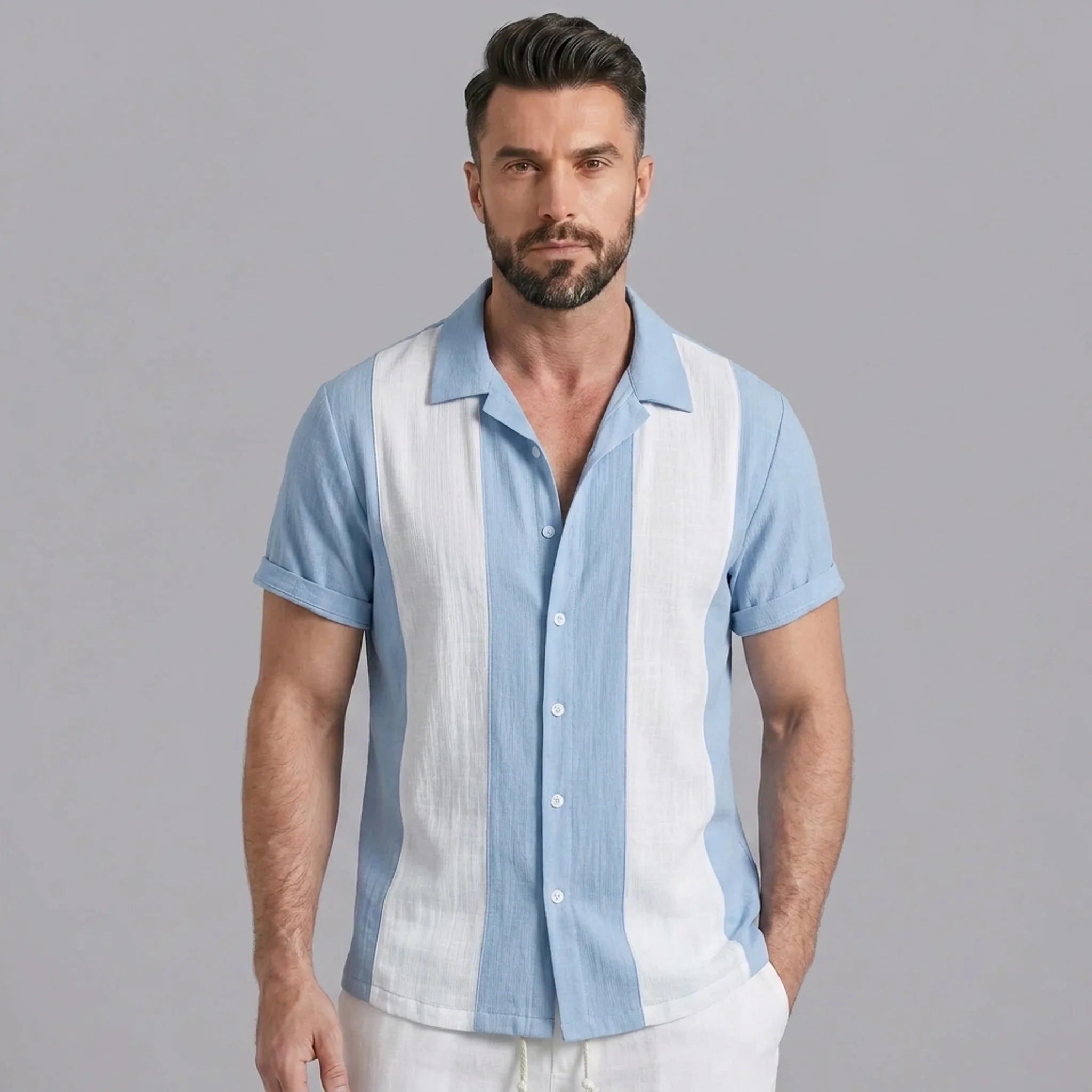 Side view of man in light blue patchwork cotton bowling shirt and straight leg linen pants