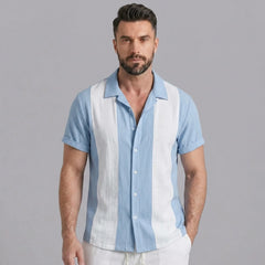 Side view of man in light blue patchwork cotton bowling shirt and straight leg linen pants