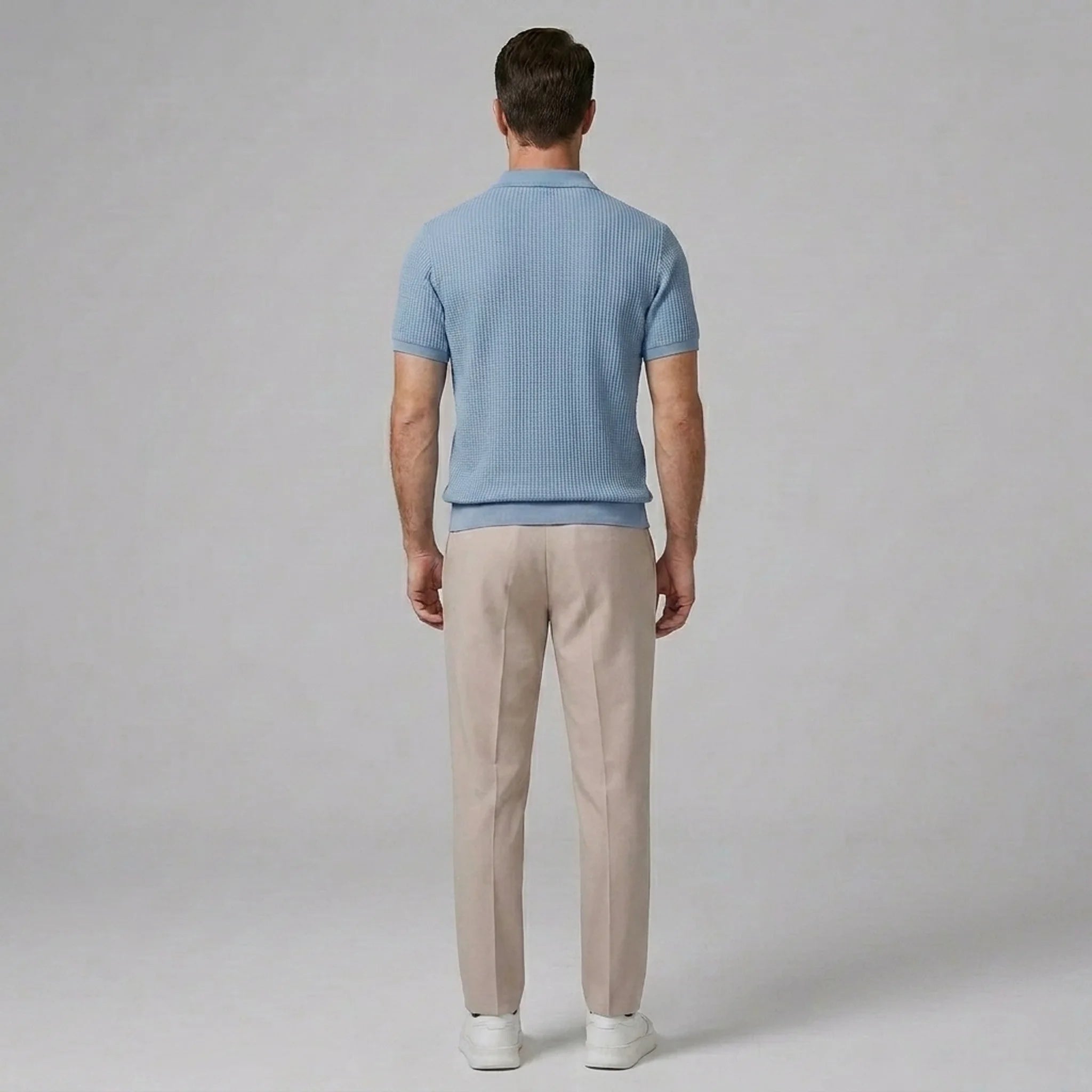 Side view of man in light blue waffle johnny collar polo and slim fit tapered pants