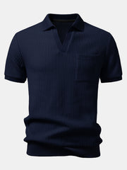 Man wearing light blue waffle johnny collar polo and slim fit tapered pants outdoor lifestyle scene