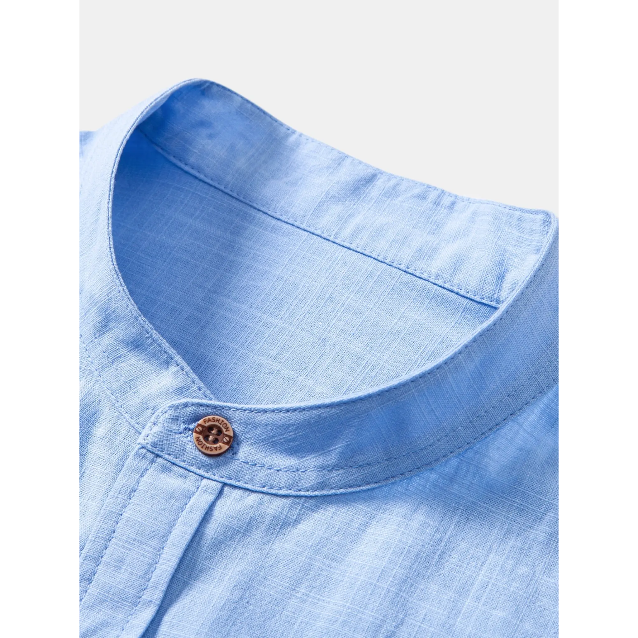 MannerCo light blue linen stand collar detail with wooden fashion button closeup