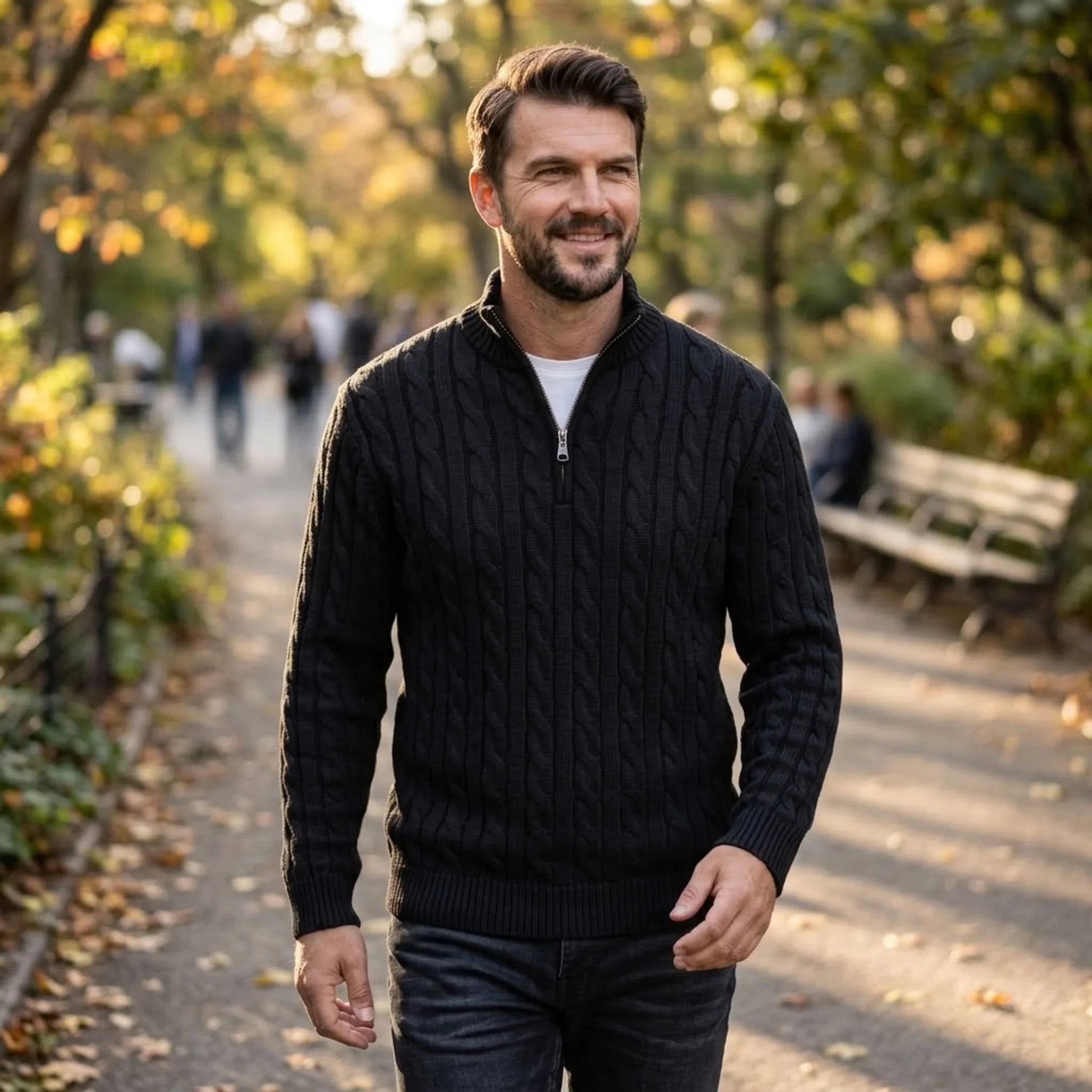 Man wearing black cable knit quarter-zip sweater in an autumn park