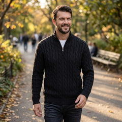 Man wearing black cable knit quarter-zip sweater in an autumn park