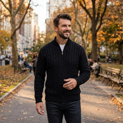 Man wearing black cable knit quarter-zip sweater on a tree-lined street