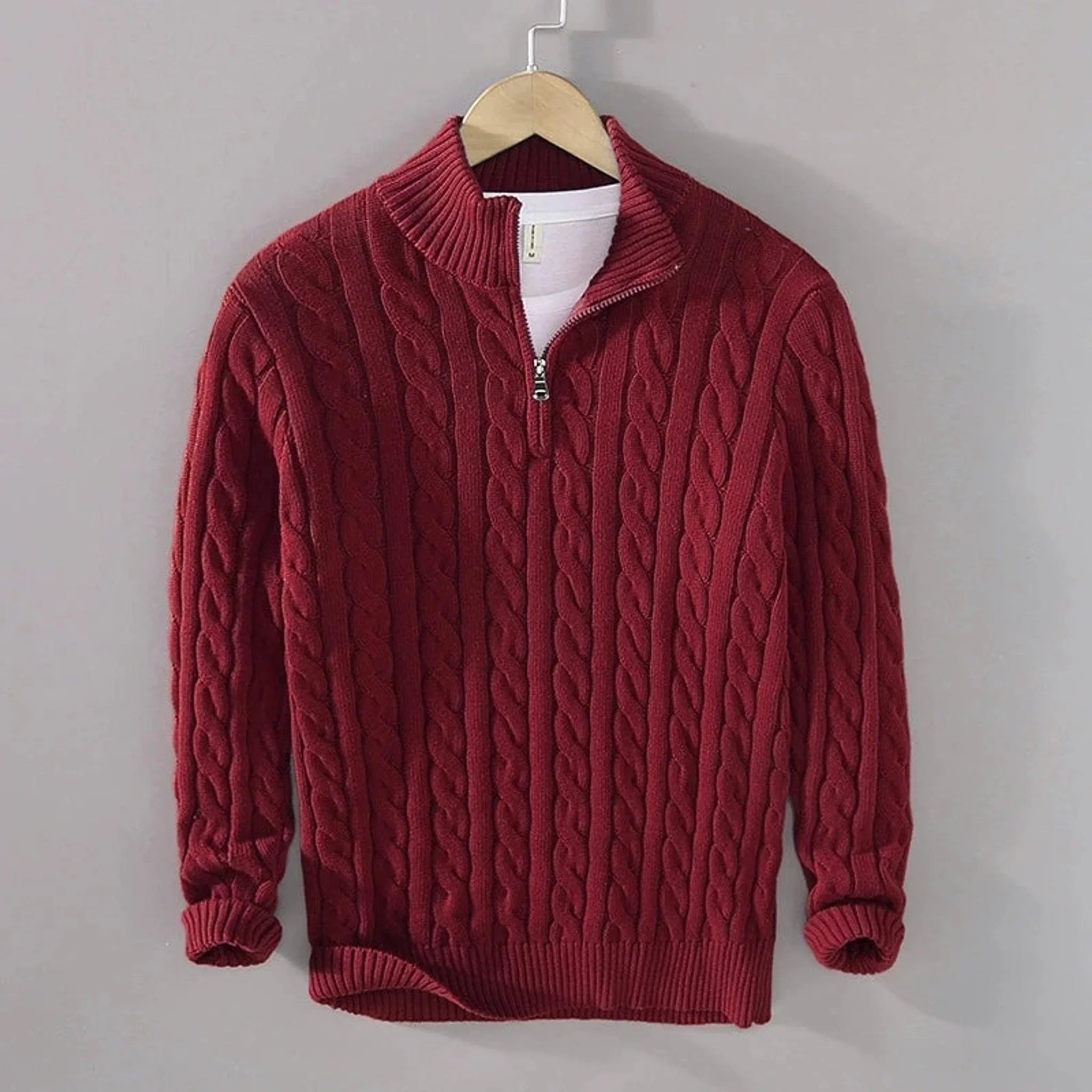 Burgundy cable knit quarter-zip sweater, front view on hanger