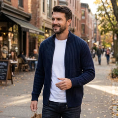 Man wearing navy cable knit zip sweater open on a city street