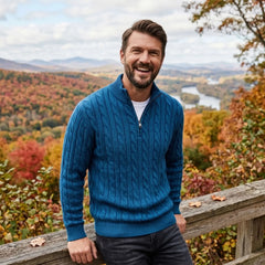 Man wearing teal blue cable knit quarter-zip sweater with autumn hills behind