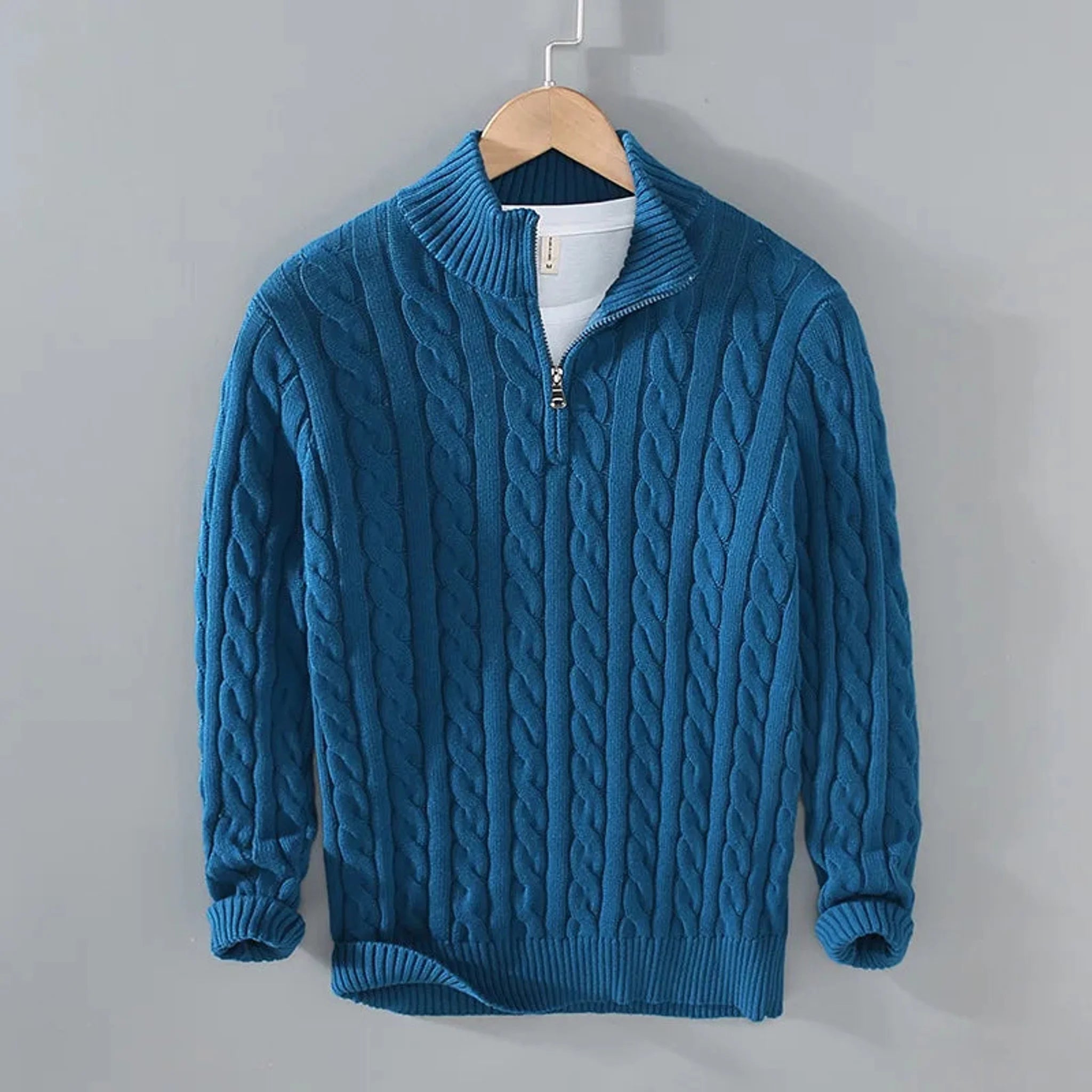 Teal blue cable knit quarter-zip sweater, front view on hanger