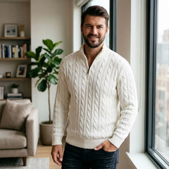 Man wearing white cable knit quarter-zip sweater in a bright room with plants
