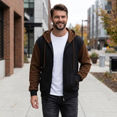 Man wearing black and coffee zip-up hoodie on a city street