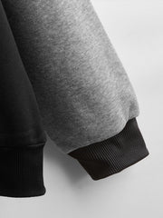 Gray hoodie sleeve with black ribbed cuff, close-up