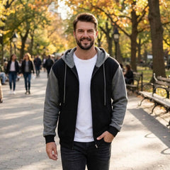 Man wearing black and gray zip-up hoodie with a white tee in an autumn park