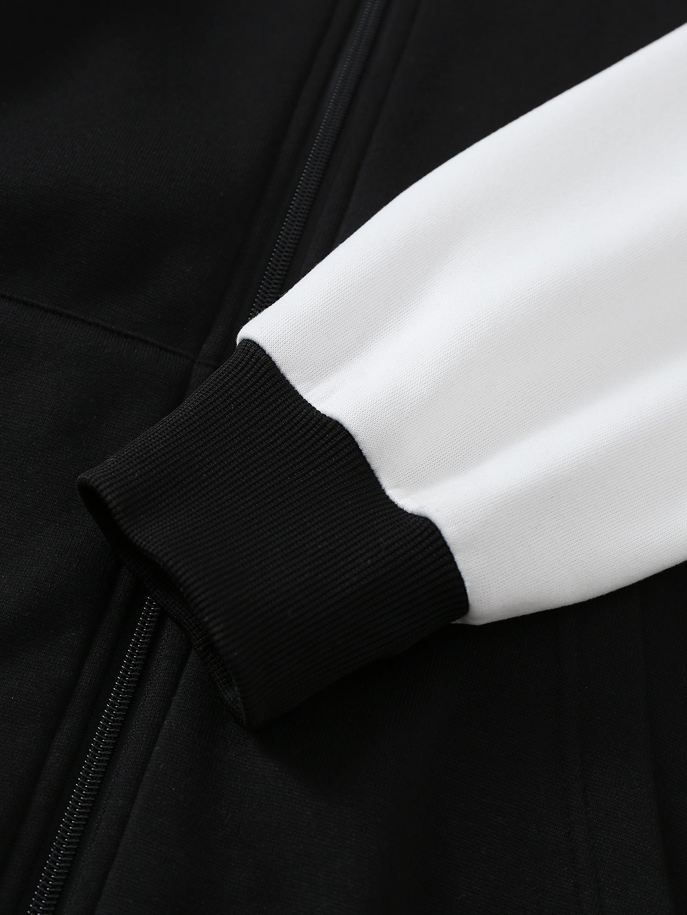 White hoodie sleeve with black ribbed cuff, close-up