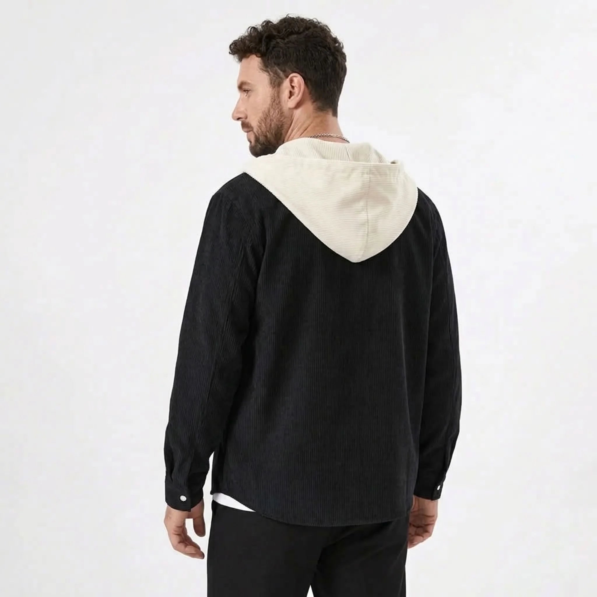 Black corduroy hooded shirt jacket with cream hood, model back view