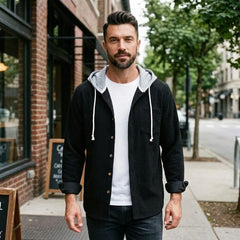 Man in black corduroy hooded shirt jacket on a city street