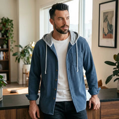 Man in blue corduroy hooded shirt jacket in a bright apartment
