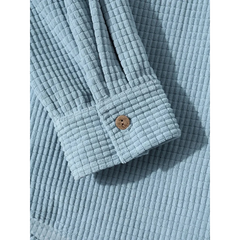 Close-up of the buttoned cuff on the light blue corduroy jacket