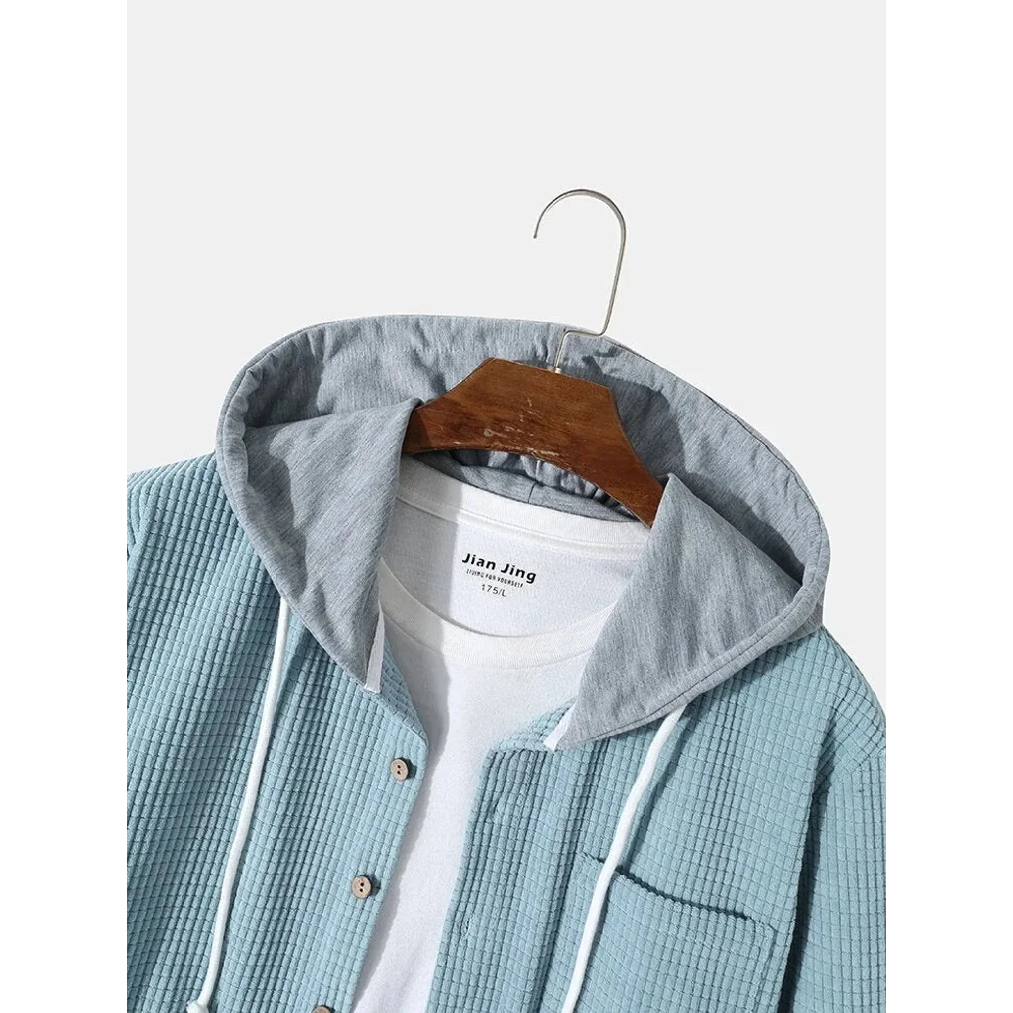 Close-up of the contrast hood and drawstring on the light blue corduroy jacket