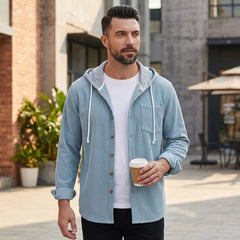Man in light blue corduroy hooded shirt jacket on a city street