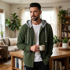Man in olive green corduroy hooded shirt jacket in a bright apartment